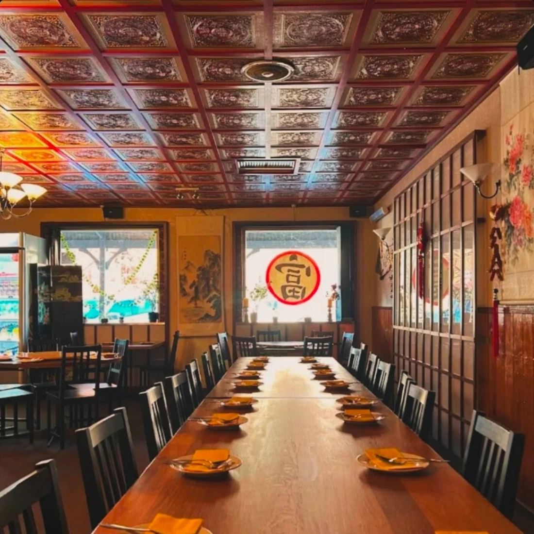 Inside Fu Wah: a long table set for dinner under the pressed-tin ceiling